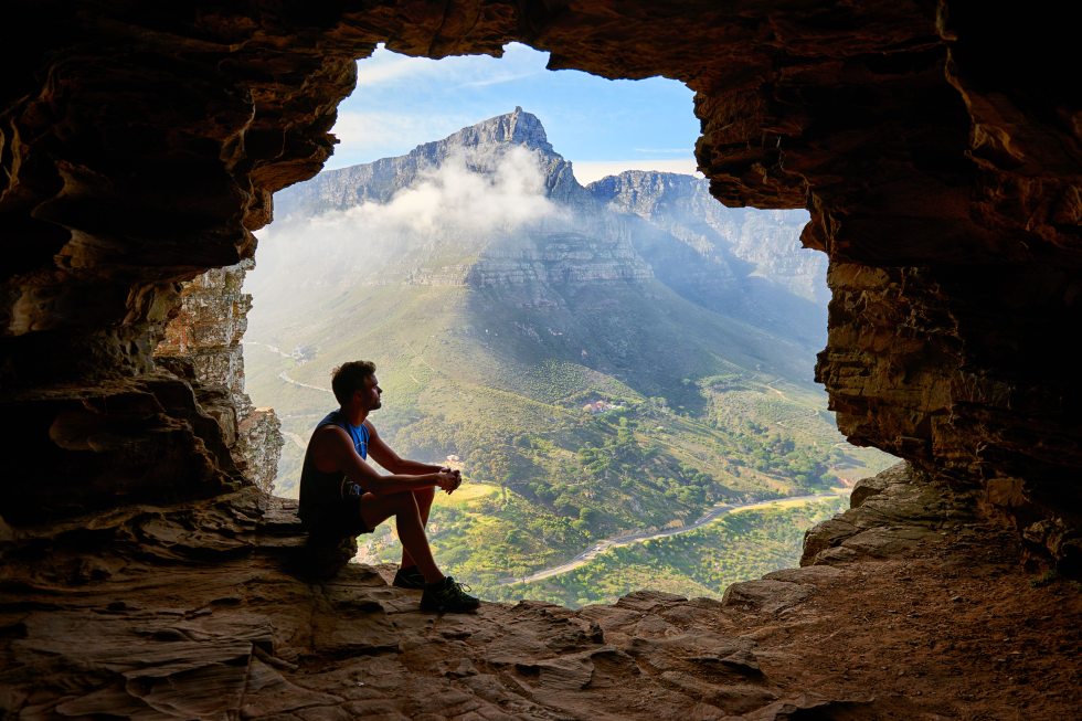 man praying in a cave